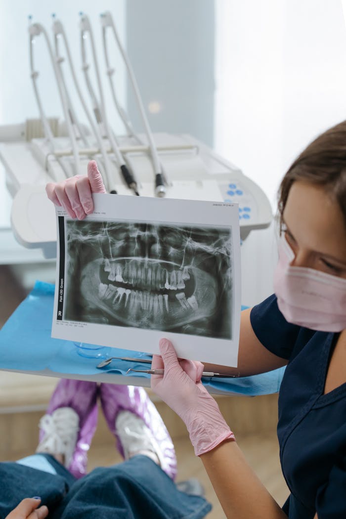 services-03 Dentist showing dental x-ray during consultation in a modern clinic setting.