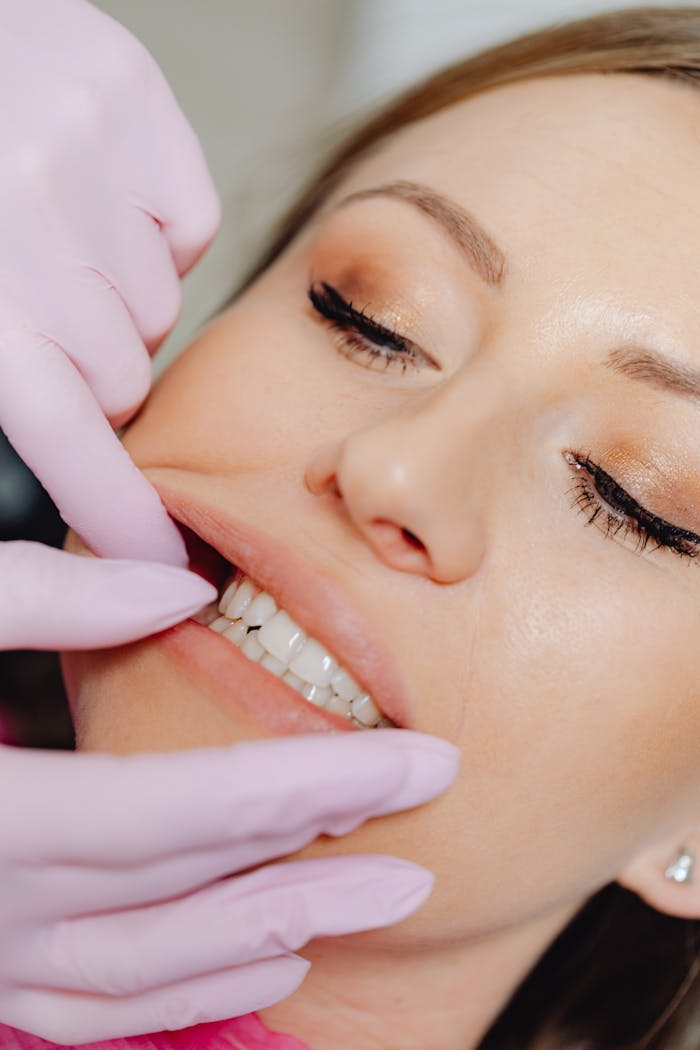 services-01 Detailed close-up of a dental examination showing a woman's teeth with latex gloves.