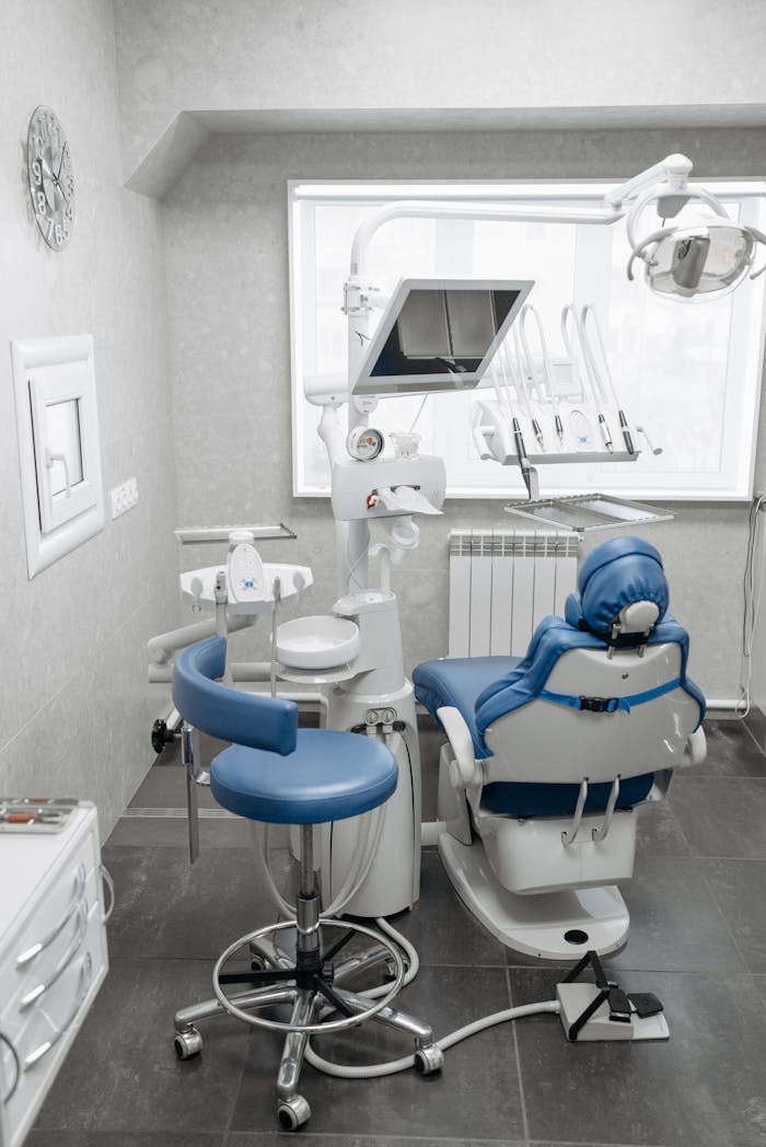 services-02 A clean and modern dental office featuring a dental chair, equipment, and bright lighting.